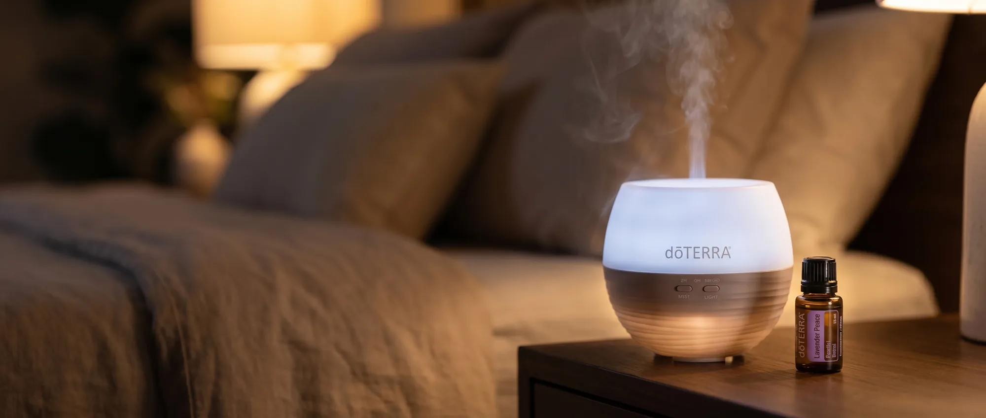 dōTERRA Petal Diffuser 2.0 glowing softly on a bedside table at night, releasing mist beside a Lavender Peace Restful Blend bottle