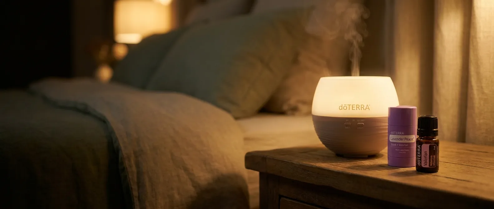A glowing dōTERRA Petal Diffuser with the Lavender Peace Stick + Valerian and the 5 mL dōTERRA Valerian oil on a bedside table at night